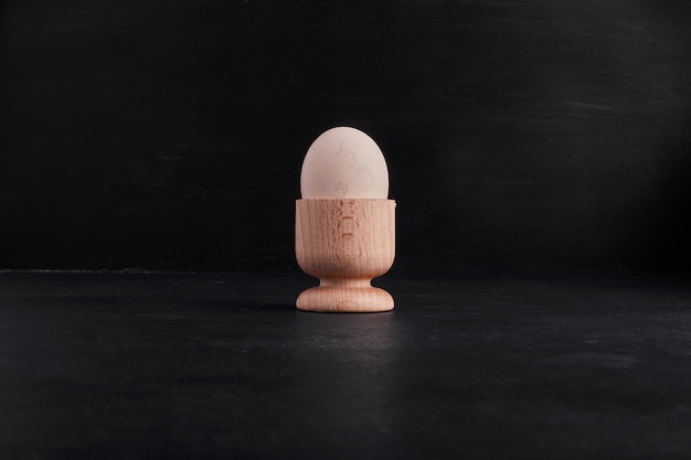 Single egg in a small wooden cup. 