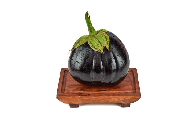 Single eggplant on a wooden platter.