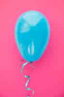 Foto gratuita singolo palloncino blu chiaro su sfondo rosa