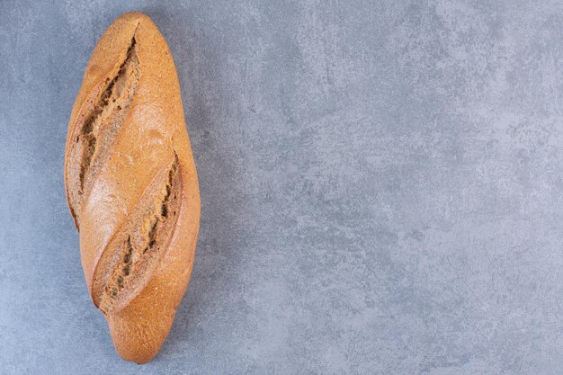 Буханка хлеба батон на мраморном фоне. Фото высокого качества