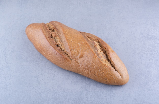 Буханка батонного хлеба на мраморной поверхности