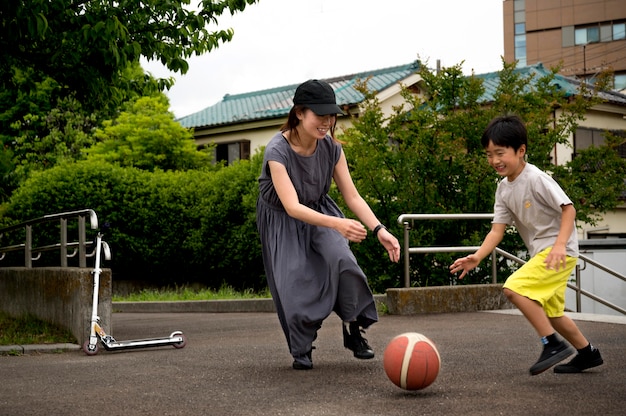 無料写真 彼女の息子とバスケットボールをしているシングルマザー