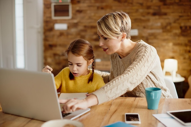 Free photo single mother and daughter using laptop while homeschooling