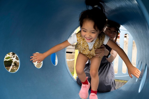 Free photo single mother playing with her daughter in a park