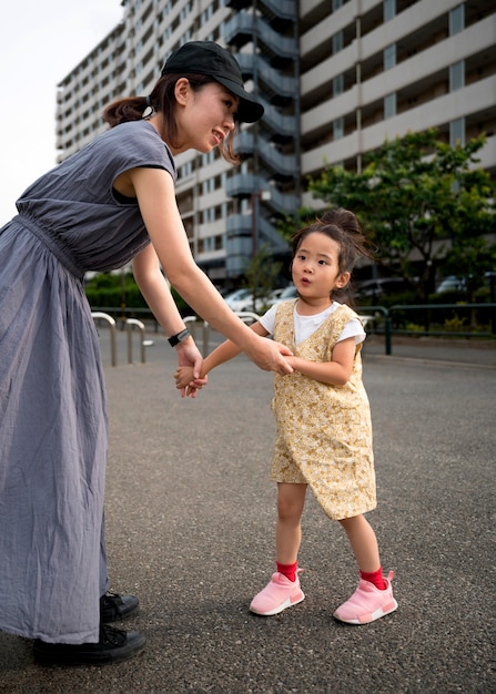 Free photo single mother playing with her daughter in a park