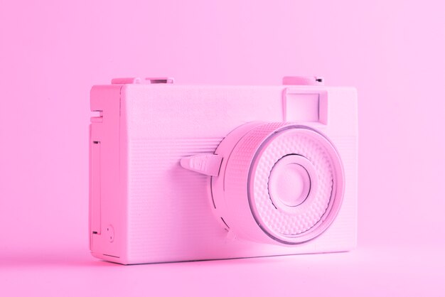 色付きのピンクの背景に対して単一の塗られたカメラ