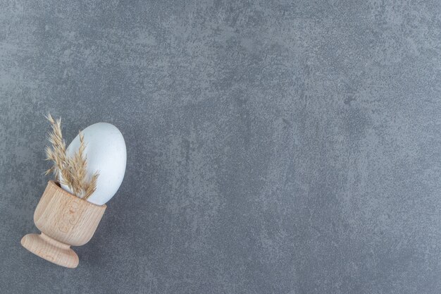 Single raw egg on marble background.