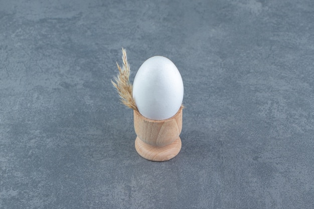 Single raw egg on marble background.