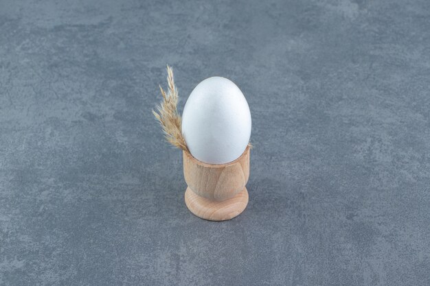 Одно сырое яйцо на мраморном фоне.