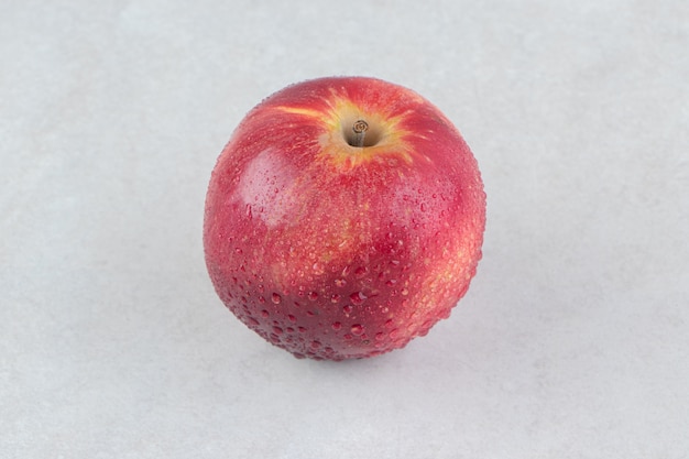 石のテーブルの上の単一の赤いリンゴ。