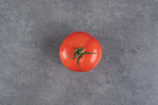 Free photo single red tomato on marble background. high quality photo