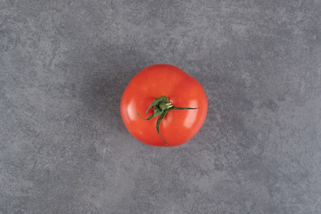 Single red tomato on marble background. High quality photo