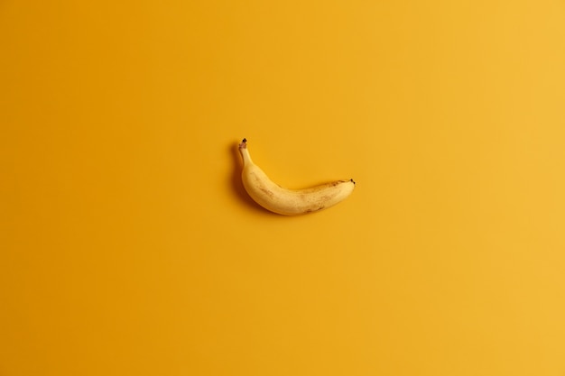 Single ripe delicious yellow banana isolated over studio background. Bright color prevails. Tropical fruit for your tasty snack. Appetizing edible product. Empty space for text or information