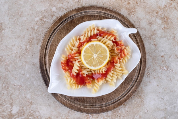 Foto gratuita singola porzione di maccheroni appena sfornati su superficie di marmo.