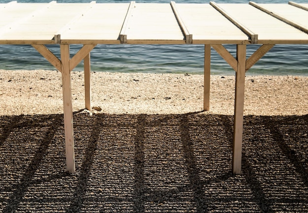 Single sun canopy stands on a pebbly beach on a sunny day City beach Black Sea coast