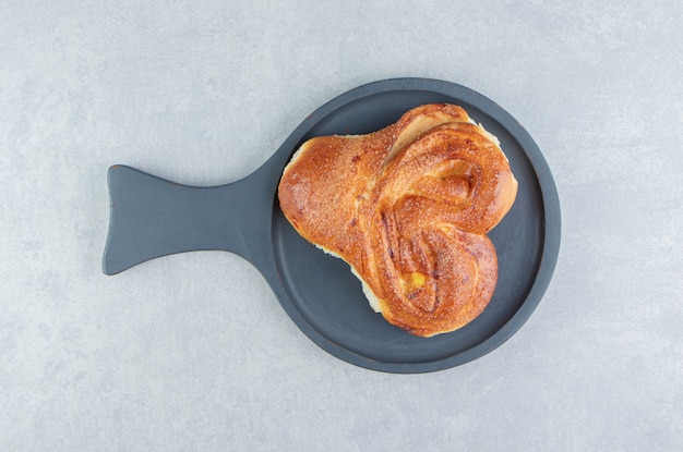 Single sweet pastry on black board. 