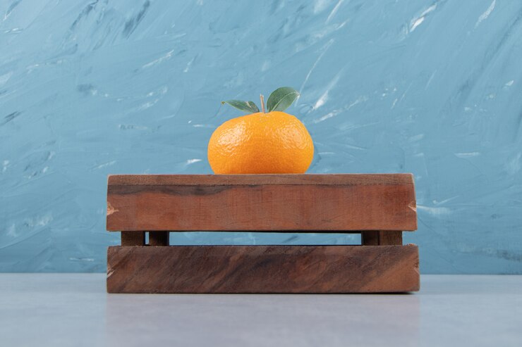 Free Photo single tasty clementine on wooden box
