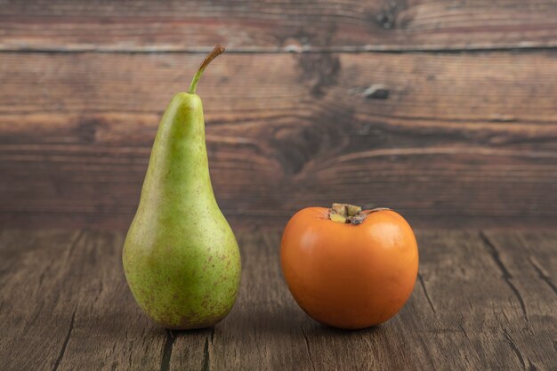 単一の丸梨と木製の背景においしい柿