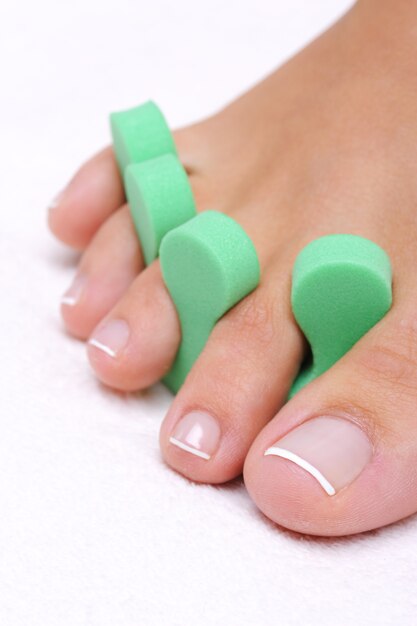 Single  woman foot with pedicure tool on 
