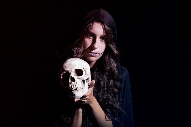 Free photo sinister female with human skull