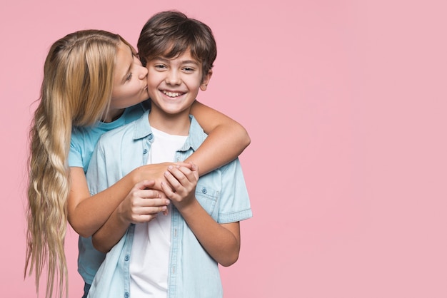 Free photo sister kissing brother on cheek