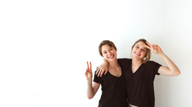 Sister making victory sign isolated over white background