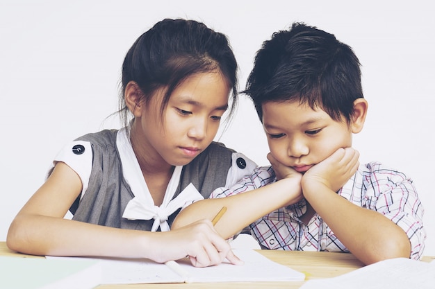 Sister try to teach her naughty younger brother to do homework