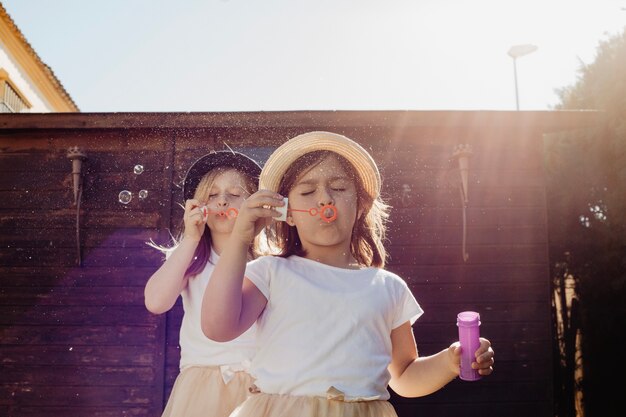 Sisters blowing bubbles near shed