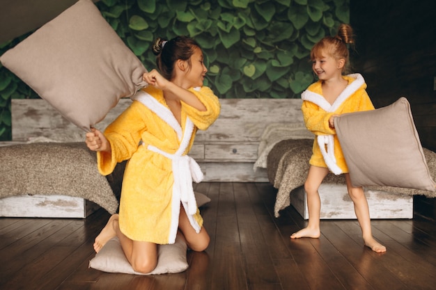 Free photo sisters fighting with pillows