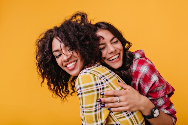 Sisters have not seen each other for long time and tanned girl rushed to embrace mulatto in the yellow top.