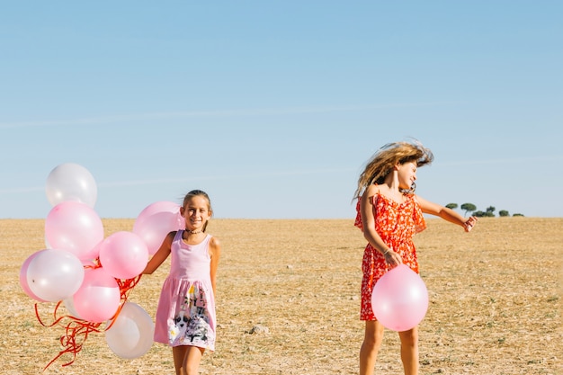 Бесплатное фото Сестры веселятся с воздушными шарами