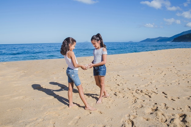 Sisters playing with a seashell