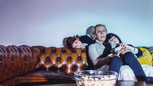 Sisters with mother watching TV