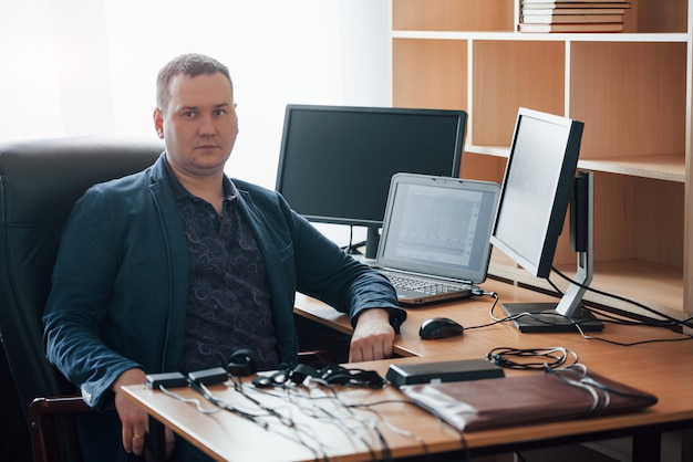 Free photo sitting on the black chair. polygraph examiner works in the office with his lie detector's equipment