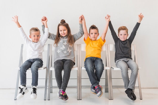 Free photo sitting children with their hands up