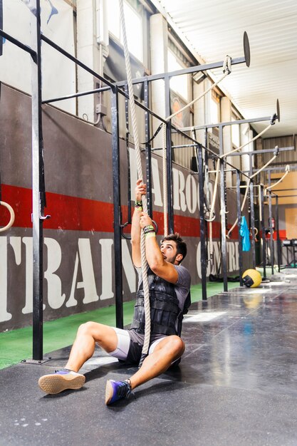 Sitting man pulling on rope