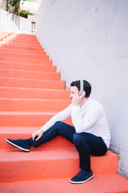 Sitting man using earphones