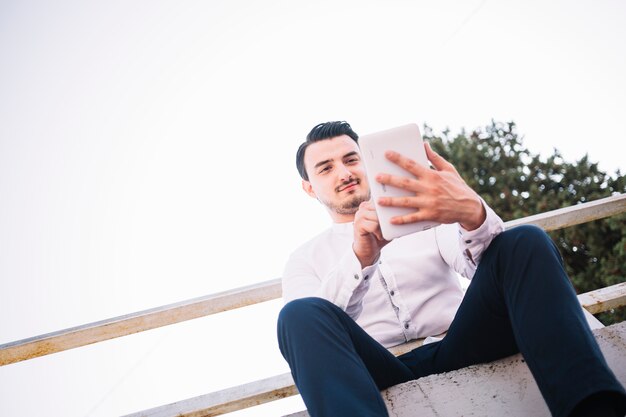 Sitting man using tablet