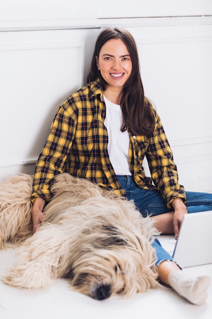 Бесплатное фото Сидя современная женщина с собакой