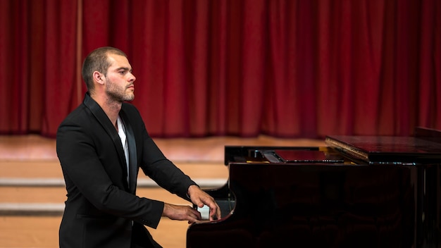 Free photo sitting musician playing piano