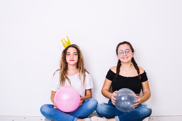 Сидящие подростки, играющие с воздушными шарами