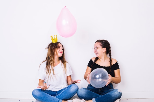 Free photo sitting teenagers playing with balloons