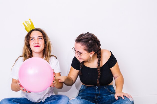 Sitting teenagers playing with balloons