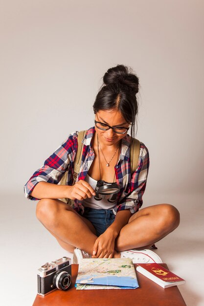 Sitting tourist woman using magnifying glass