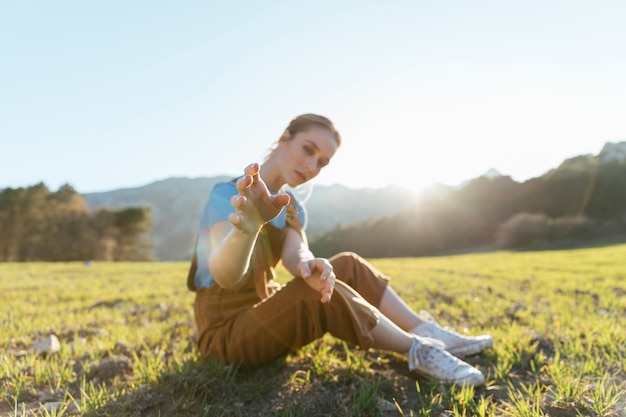 Free photo sitting woman reaching with hands