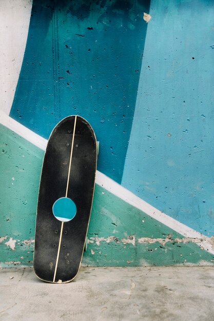 コンクリート壁に傾いたスケートボード