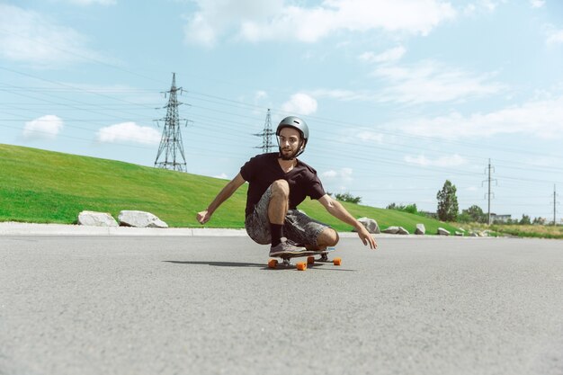 Skateboarder doing a trick at the city's street in sunny day