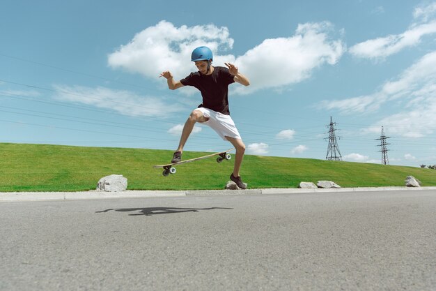 Skateboarder doing a trick at the city's street in sunny day.