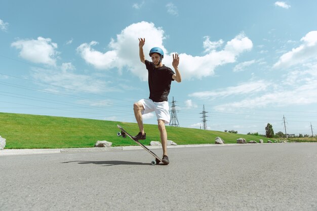 Skateboarder doing a trick at the city's street in sunny day.