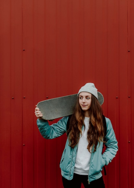 Ragazza di skateboarder e il suo skate in città